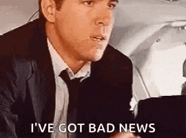 a man in a suit and tie is sitting on a plane and talking to someone .