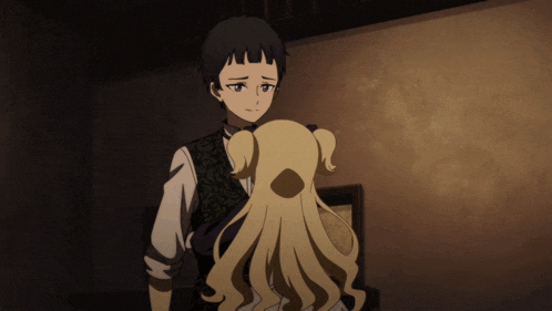 a boy and a girl are looking at each other in a dark room
