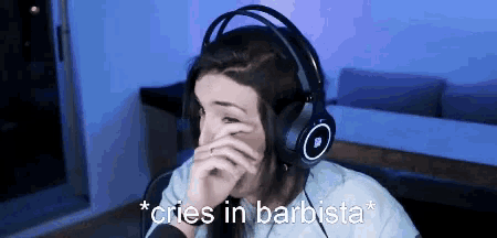 a woman wearing headphones covering her face with her hand and the words * cries in barbista *