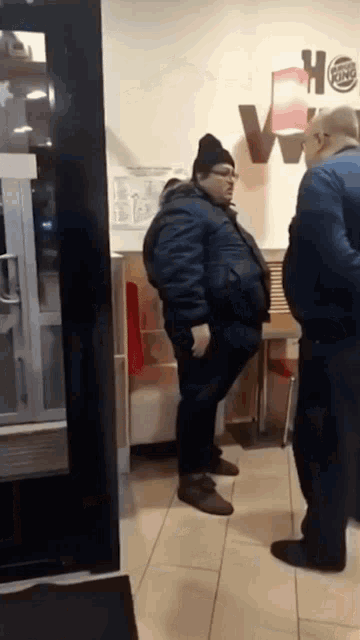 a burger king sign is on the wall behind a man