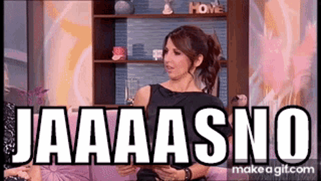 a woman in a black dress is sitting on a couch with the words jaaaasno written on the screen .