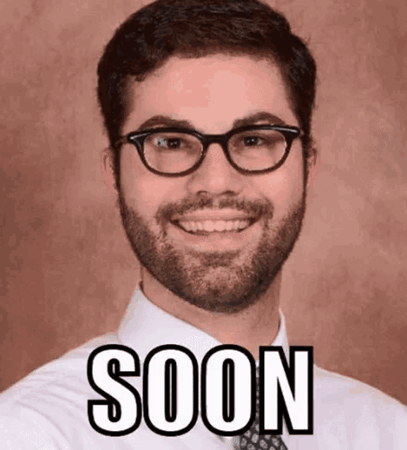 a man with glasses and a beard is wearing a white shirt and tie with the word soon written on the front .
