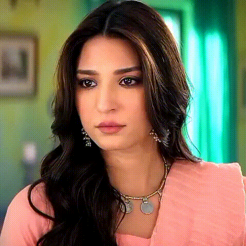the woman is wearing a pink dress and a necklace .