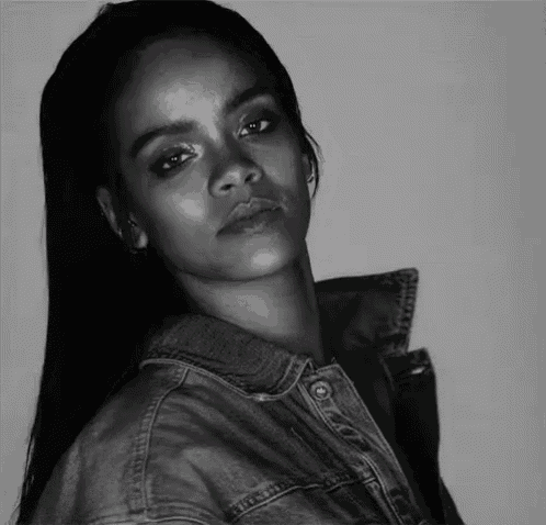 a woman is wearing a denim jacket and looking at the camera