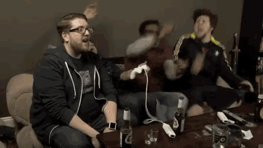 a group of men are playing a video game and one of them is wearing a shirt that says ' a ' on the front