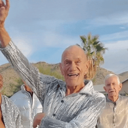 a man with his arm in the air is surrounded by three other people