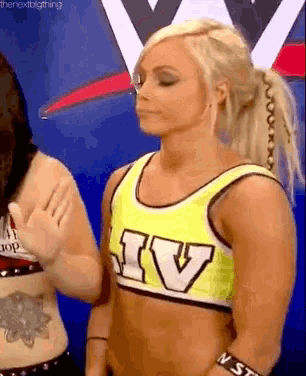 a blonde woman wearing a yellow top with the letter iv on it