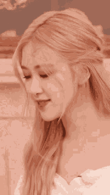 a close up of a woman laughing with her mouth open and her hand up .