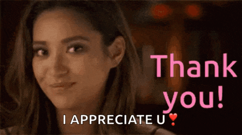 a woman is smiling in front of a sign that says thank you