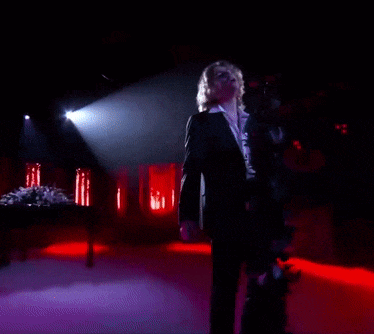 a person is singing into a microphone in a dark room