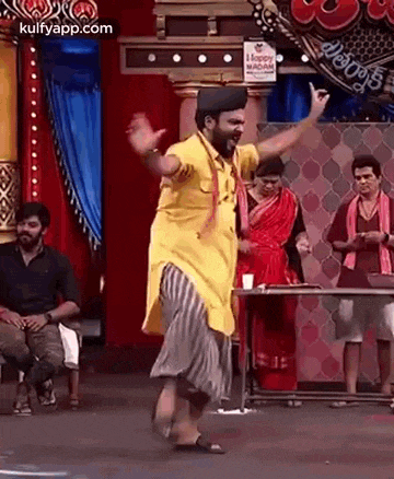 a man is dancing on a stage in front of a crowd .