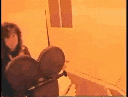 a woman is sitting in a chair in a room with a camera .