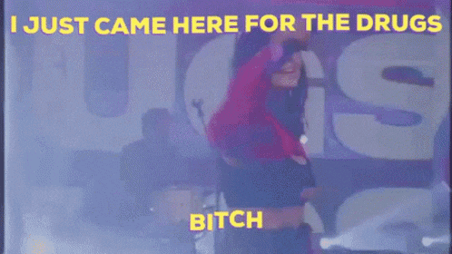 a woman is hugging another woman in front of a microphone with the words `` i just came here for the drugs '' .