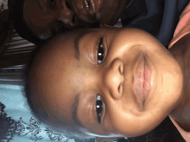 a close up of a child 's face with a woman behind her