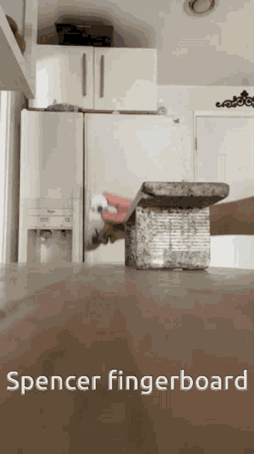 a spencer fingerboard is sitting on a wooden table in a kitchen