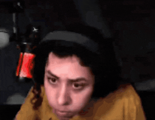 a person wearing headphones and a headband is looking at the camera .