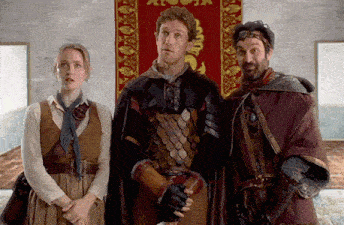 a man in armor stands next to two other people