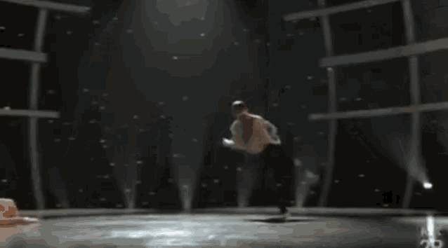 a woman is doing a handstand on a stage with a x on the bottom