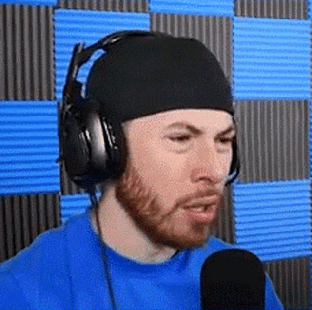 a man wearing headphones and a headband is talking into a microphone .