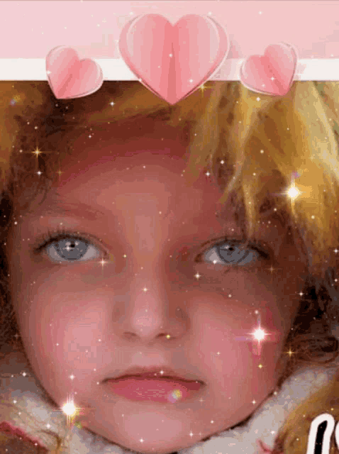 a little girl 's face is surrounded by pink hearts