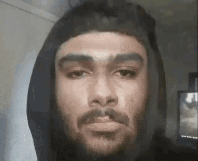 a man with a beard and mustache is wearing a hoodie .