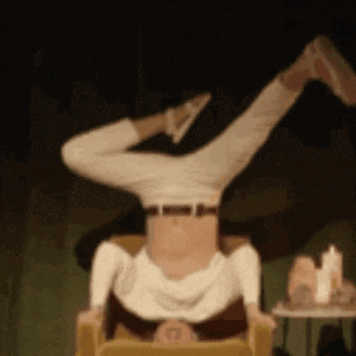 a person is doing a handstand in a chair