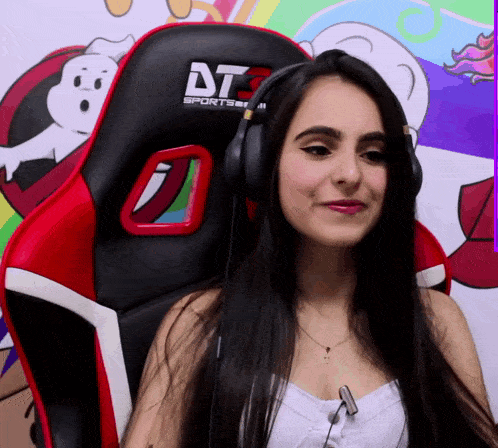 a woman wearing headphones sits in a red and black chair that says dt sports