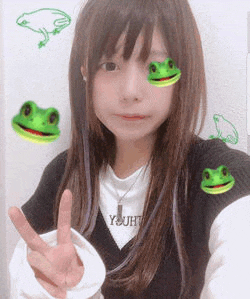 a girl with green frogs on her face is giving a peace sign .