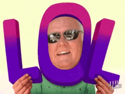 a man wearing sunglasses and a purple head scarf is holding a purple lol sign .