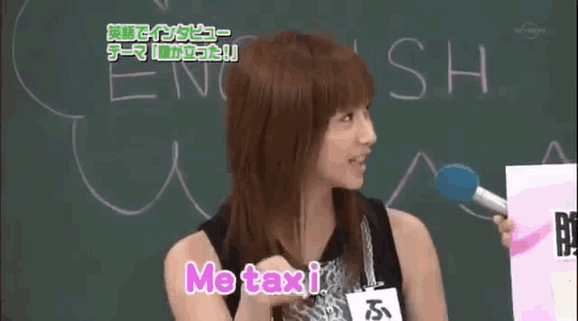 a woman is holding a microphone in front of a blackboard that says english on it