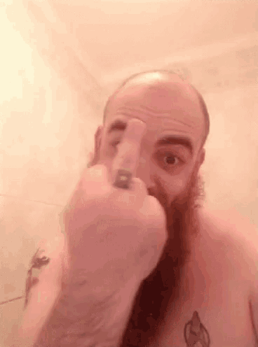 a bald man with a beard and a tattoo on his chest is holding a spray bottle in his hand .