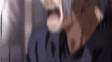 a close up of a person 's face with their mouth open and a blurry background .