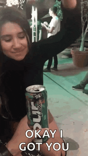 a woman is sitting next to a man holding a can of soda that says okay i got you .