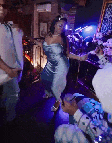 a woman in a blue dress with a crown on her head is dancing