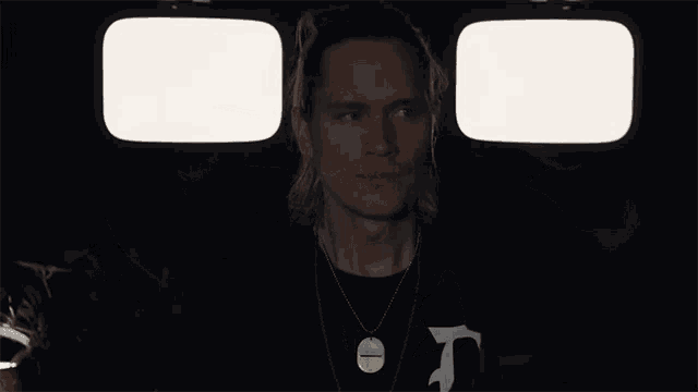 a man with the letter d on his shirt covers his eyes