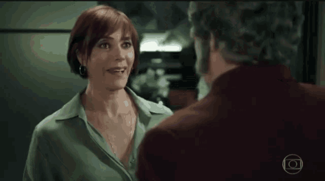 a man and a woman are standing in a living room holding hands .
