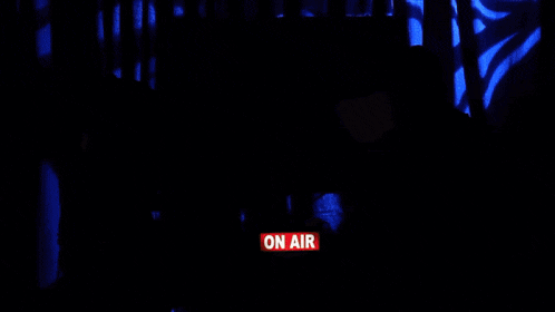 a man and woman are sitting in front of a sign that says hey crew