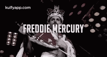 freddie mercury is wearing a crown and holding a microphone in his hand .