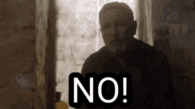a man with a beard is sitting in front of a window with the word no written on it