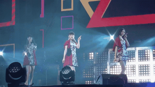 a group of women are standing on a stage with a large z in the background