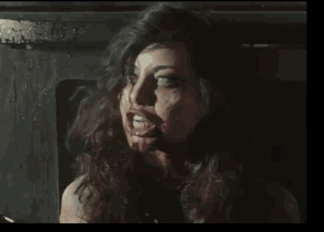 a woman with blood on her face is making a face