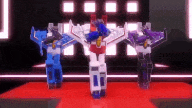 three robots are dancing on a red carpet in a room .