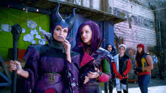 a woman in a purple costume is standing next to a man in a yellow jacket