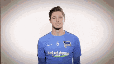 a man wearing a blue shirt with bet-at-home written on it