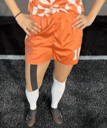 a female soccer player wearing shorts with the number 10 on the back
