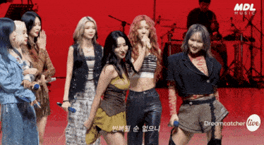 a group of women standing in front of a red background with mdl music written on it