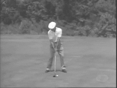 a black and white photo of a man swinging a golf club on a golf course