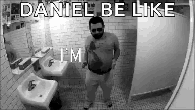 a man is standing in a bathroom with a beard and sunglasses on .