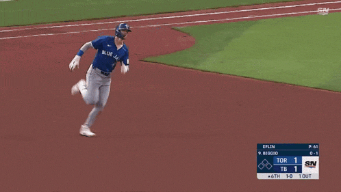 a baseball player for the blue jays is running towards a base