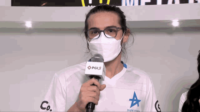 a man wearing glasses and a mask holds a microphone with a tag that says pg12